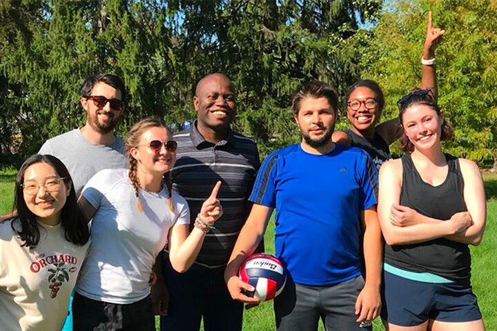 A happy and diverse group of IU students, faculty, and staff poses outdoors.